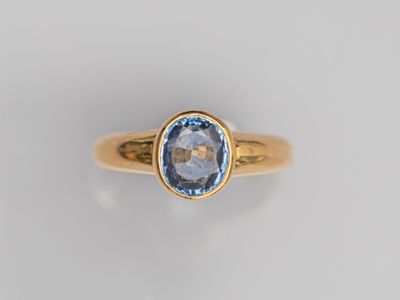 une bague en or sertie d'une topaze bleue au centre