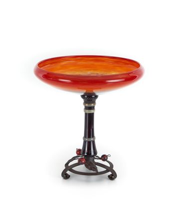 une table orange et noire avec un plateau en verre posé sur un piètement en métal