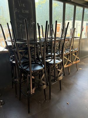 tables and chairs in a room with a chalk board on the wall