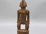 une statue en bois d'un homme avec un chapeau sur la tête