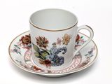 a cup and saucer on a saucer on a white table