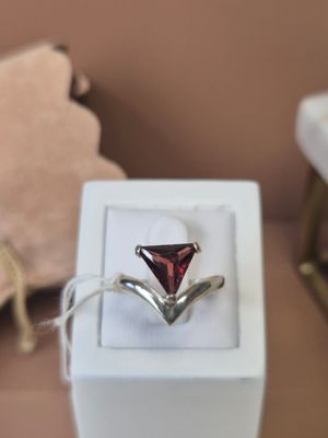a ring with a red stone in it in a white box