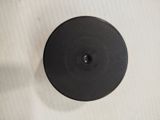 a black knob on a white wall with a white background