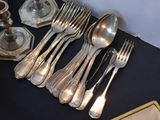 a lot of silverware on a table with a picture frame