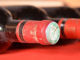 several bottles of wine are lined up on a red table