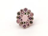 une image représentant une bague rose et verte posée sur une surface blanche