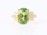 une bague en or jaune sertie d'une tourmaline verte ovale et de diamants
