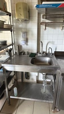a kitchen with a sink and shelves in it