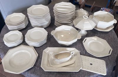 une table sur laquelle se trouvent beaucoup d'assiettes et de bols