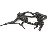 pair of bronze figurines of monkeys fighting each other on a white background