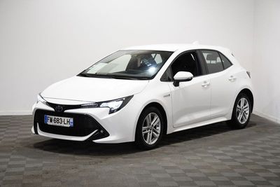 La Toyota Corolla blanche est garée dans une pièce blanche.