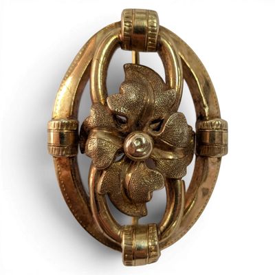 a close up of a brooch with a flower on it