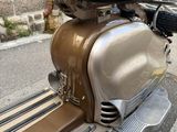 a motor scooter that is parked on the side of the street