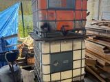 un grand conteneur métallique posé sur un tas de bois