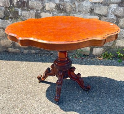 a small table with a wooden top on a sidewalk