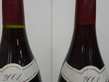 two bottles of red wine are sitting on a table