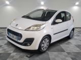la petite voiture blanche est garée sur un sol en damier