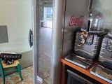 a coke machine in the corner of a kitchen