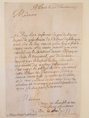 un vieux papier sur lequel il y a des inscriptions est accroché au mur