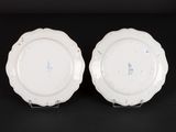 two white plates are sitting on a black surface