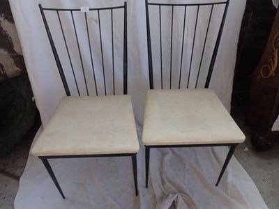 pair of black metal chairs with cream seat cushions