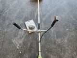 une photo d'une débroussailleuse posée sur un sol en béton