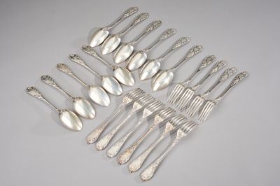 six silverplated spoons and six silverplated spoons on a white surface