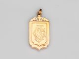 un gros plan d'un pendentif en or orné d'un blason
