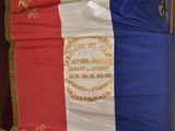 an old french flag hanging on a wall in a room