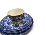 a stack of blue and white plates with a cup and saucer on top