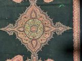 an image of a green and red rug with a floral design on it