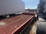 a semi truck with a trailer attached to the back of it