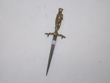 a close up of a knife on a white surface with a bird on it