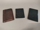 three different types of leather wallets sitting on a white surface