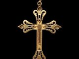 a gold cross with a crown on top of it on a black background