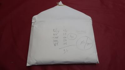 a piece of paper with writing on it on a red surface