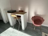 a pink chair sitting in front of a desk in a room