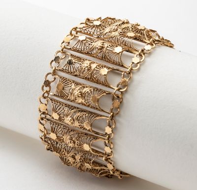 a close up of a gold bracelet on top of a napkin
