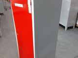 an image of a red and white refrigerator in a warehouse