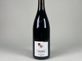 une bouteille de vin rouge posée sur une table blanche