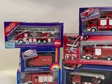 three boxed toy fire trucks and a fire truck are on a table