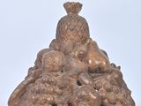 a small statue of a bird sitting on a pile of fruit