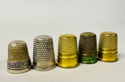 several thimbles are lined up in a row on a white surface
