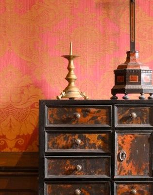 une commode sur laquelle est posée une lampe, dans une pièce