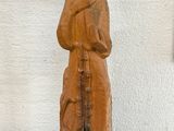 statue of a woman holding a cross on a black base
