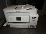a printer that is sitting on the floor next to a window
