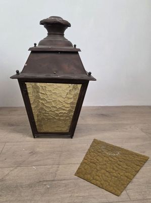 an old fashioned lantern with a small piece of paper next to it
