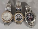 three watches are sitting side by side on a white surface