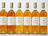six bouteilles de vin sont alignées sur une surface blanche