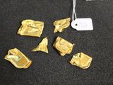plusieurs morceaux de feuille d'or posés sur une table noire